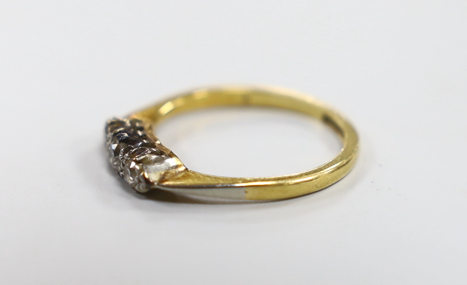 An 18ct, plat and three stone diamond ring, size N/O, gross weight 2.5 grams.